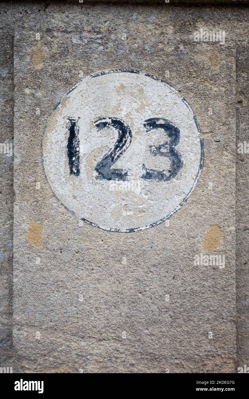 Numero civico 123 su un muro di pietra Foto Stock