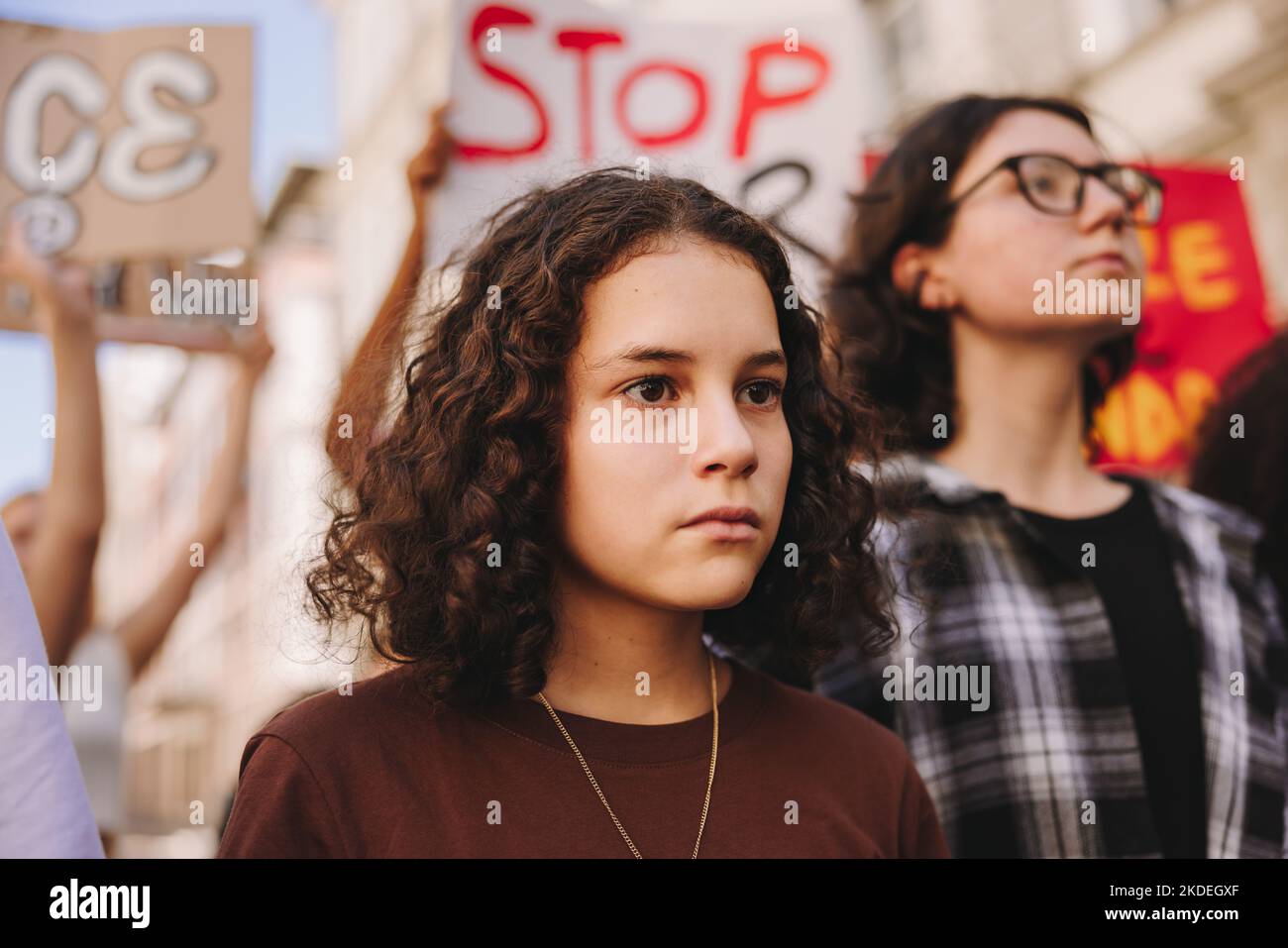 I manifestanti giovanili marciavano contro la guerra e la violenza nelle strade. Gruppo di attivisti multiculturali che sollevano manifesti anti-guerra durante una pace e un essere umano Foto Stock