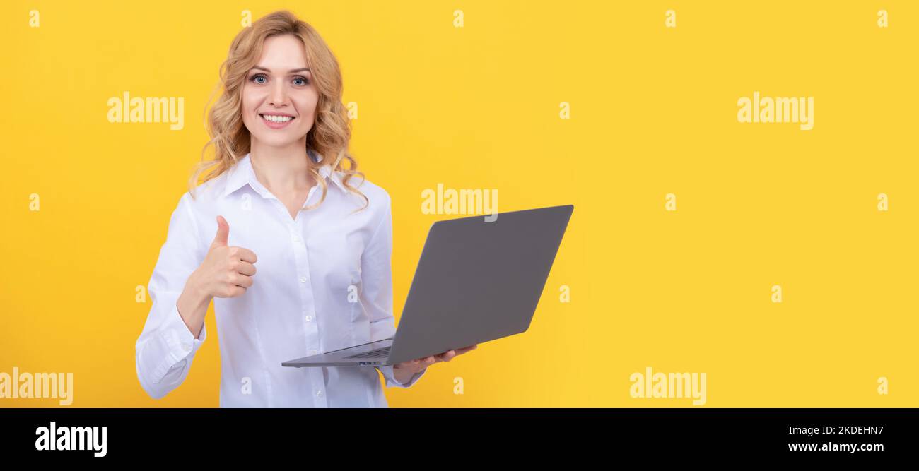 Donna isolato volto ritratto, banner con mock up spazio copia. Felice donna d'affari lavorare online con notebook su sfondo giallo mostrando pollice in alto, moder Foto Stock