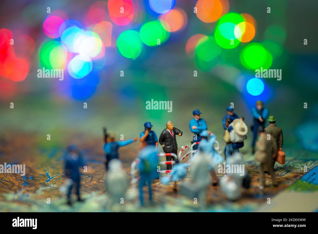 Giocattolo in miniatura persone concetto US pattugliamenti di confine contro un gruppo di migranti da Messico-blur bokeh luce sullo sfondo. Foto Stock