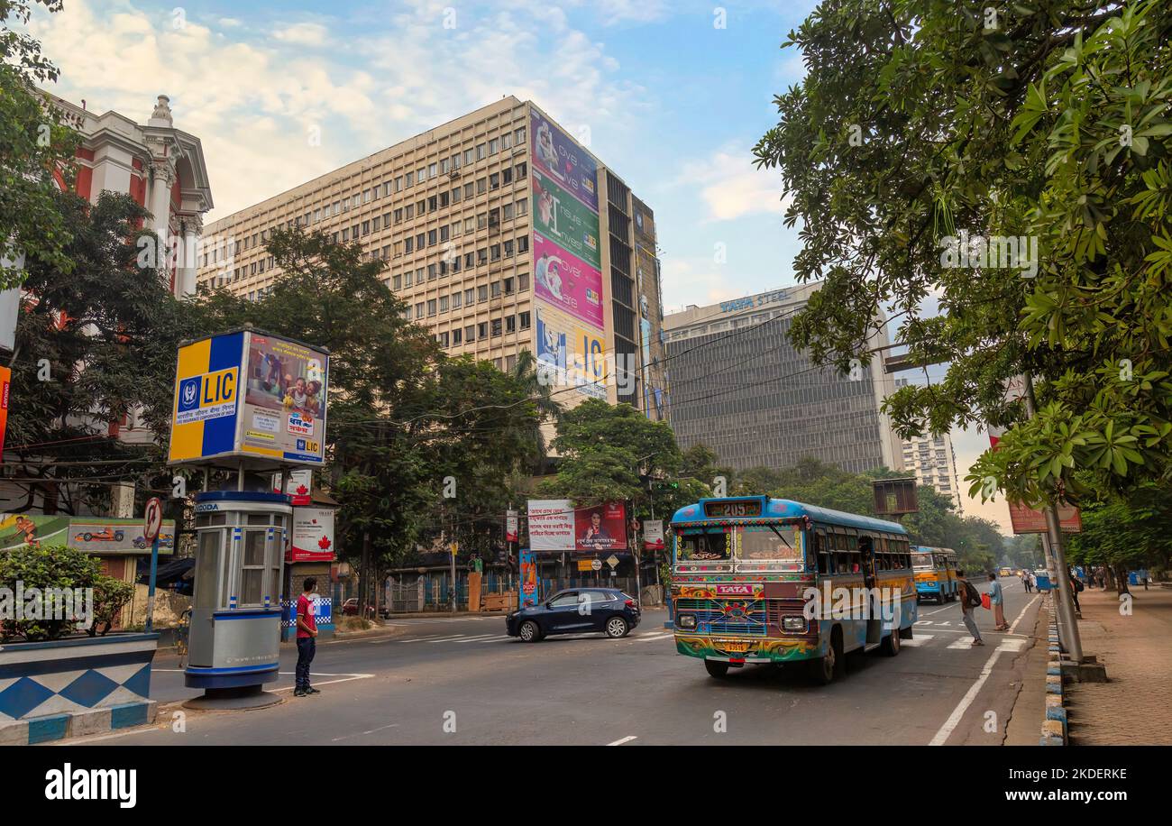 Strada cittadina con autobus di trasporto pubblico e vista degli edifici di uffici a Park Street zona di Kolkata, India Foto Stock