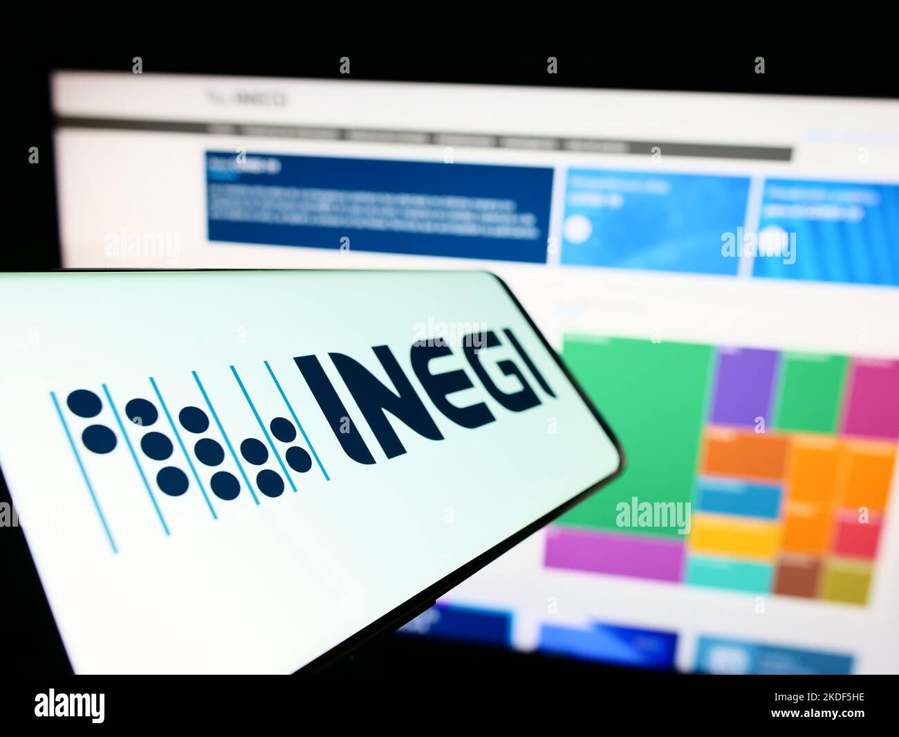Cellulare con logo dell'agenzia di statistiche messicane INEGI sullo schermo di fronte al sito web. Messa a fuoco al centro a sinistra del display del telefono. Foto Stock