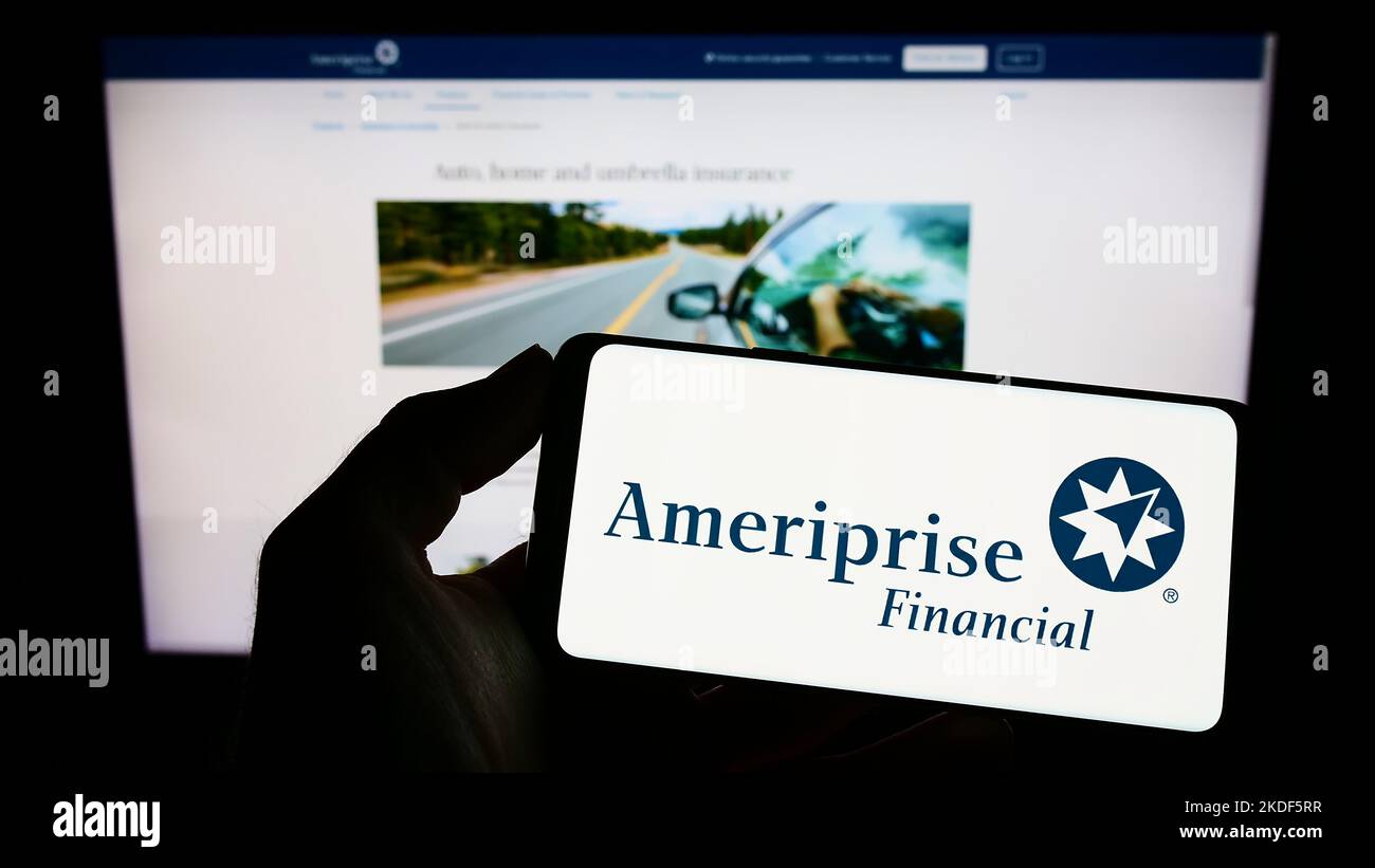 Persona che tiene lo smartphone con il logo della società americana Ameriprise Financial Inc. Sullo schermo di fronte al sito Web. Messa a fuoco sul display del telefono. Foto Stock