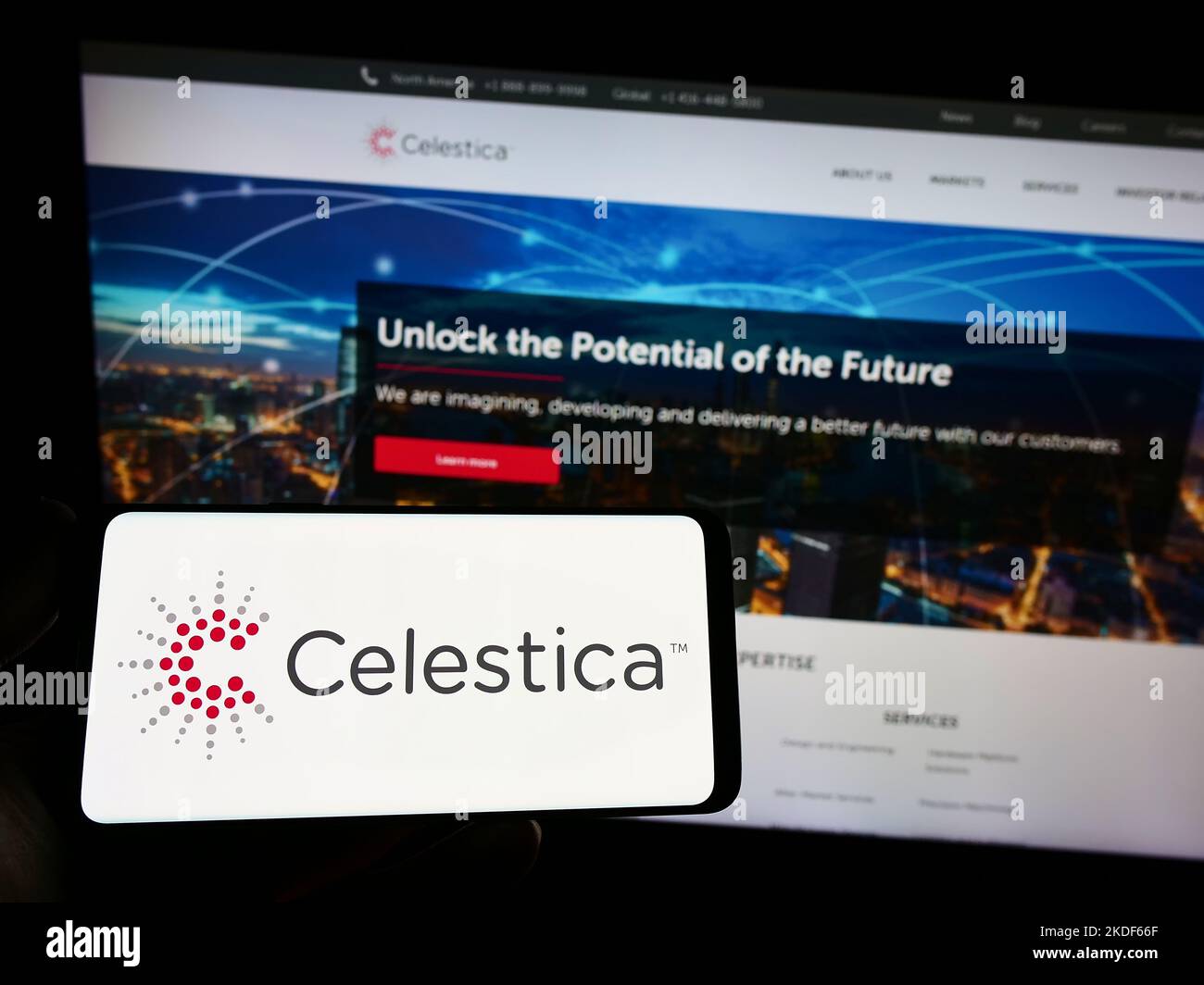 Persona che tiene uno smartphone con il logo della società di elettronica canadese Celestica Inc. Sullo schermo di fronte al sito Web. Messa a fuoco sul display del telefono. Foto Stock