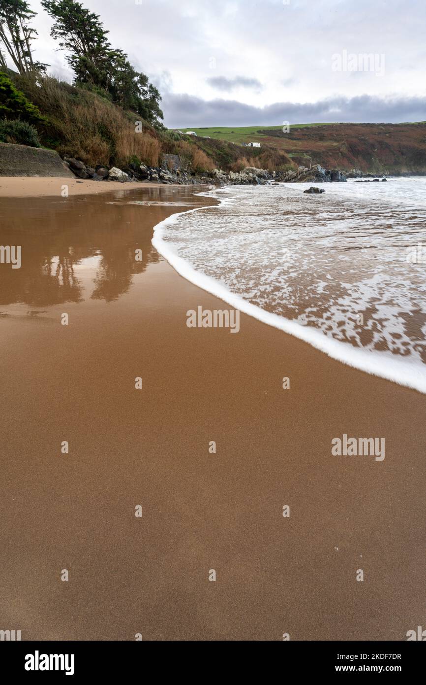 ritirando la marea su una spiaggia sabbiosa Foto Stock