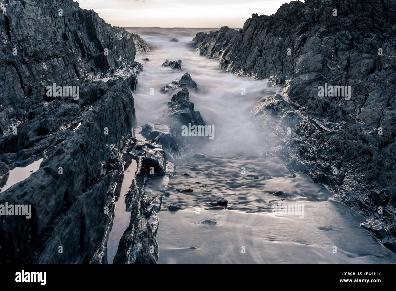 Marea entrante in un torrente roccioso Foto Stock