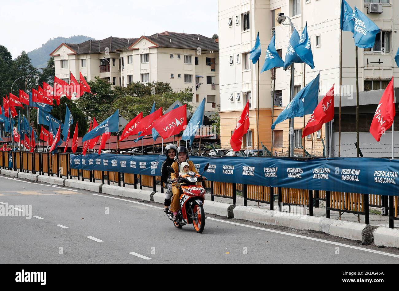 Un motociclista passa davanti alle bandiere dei partiti politici a Kuala Lumpur. I malesi andranno ai sondaggi per le elezioni generali del 15th (GE15) il 19 novembre 2022. Le 3 principali coalizioni del partito in competizione sono Alleanza della speranza, o Harapan pakatan (bandiere rosse) - opposizione, fronte nazionale, o Barisan Nasional (bandiere blu) - attuale governo di custode e Alleanza Nazionale, o Perikatan Nasional (bandiere blu chiaro) - attuale governo di custode Foto Stock