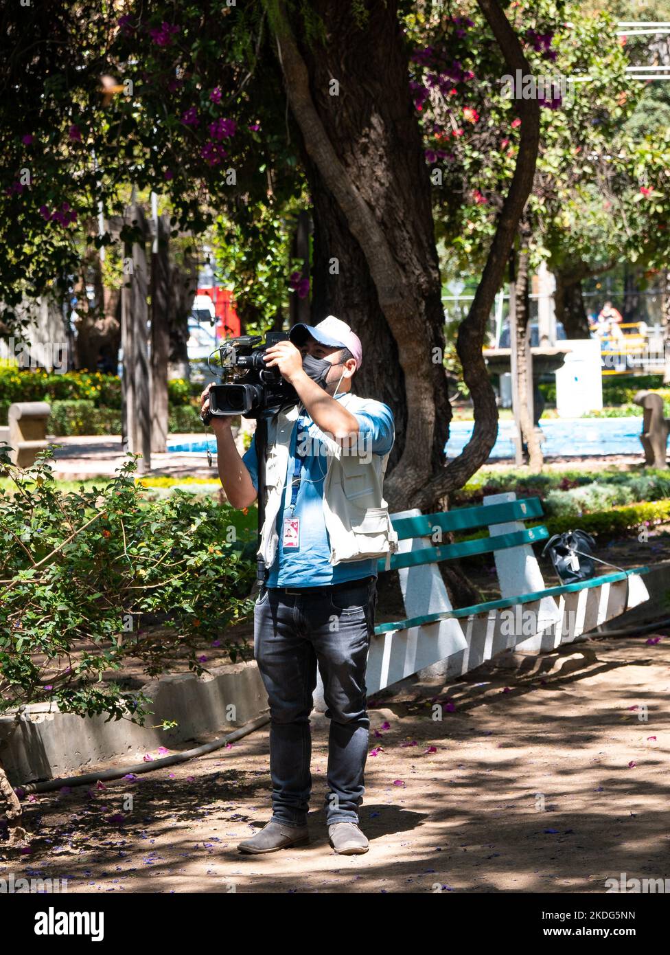 Cochabamba, Bolivia - Settembre 21 2022: Giovane indigeno con maschera nera spara video con fotocamera in un giorno di sole Foto Stock