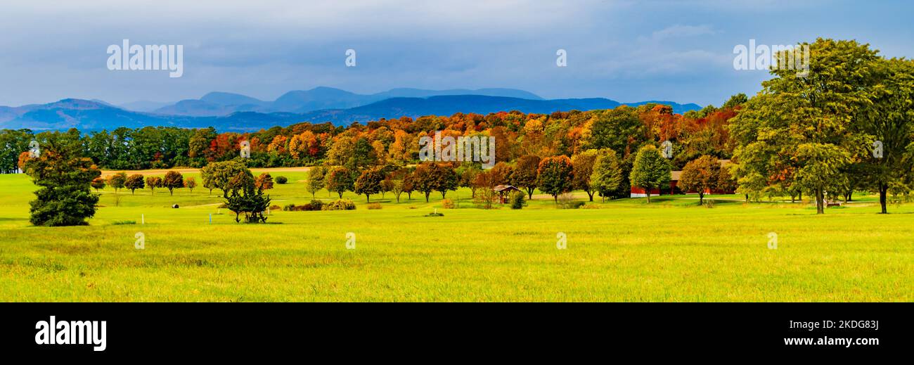 Prati e campi della fattoria del Vermont in autunno con le Montagne Adirondack di New York in lontananza Foto Stock