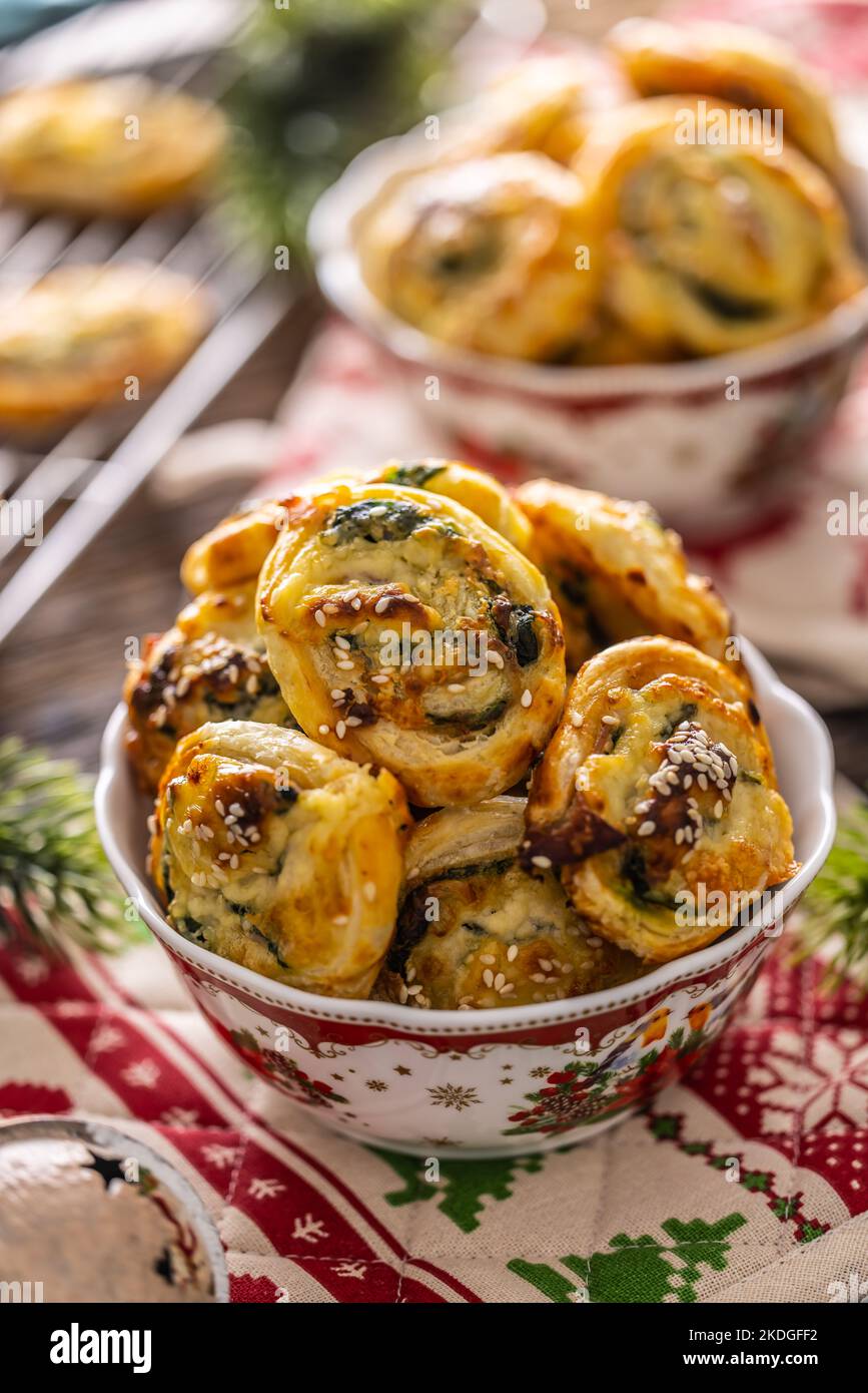 Dolci salati natalizi, mini torte di pizza in un tipico piatto natalizio e decorazioni natalizie. Foto Stock