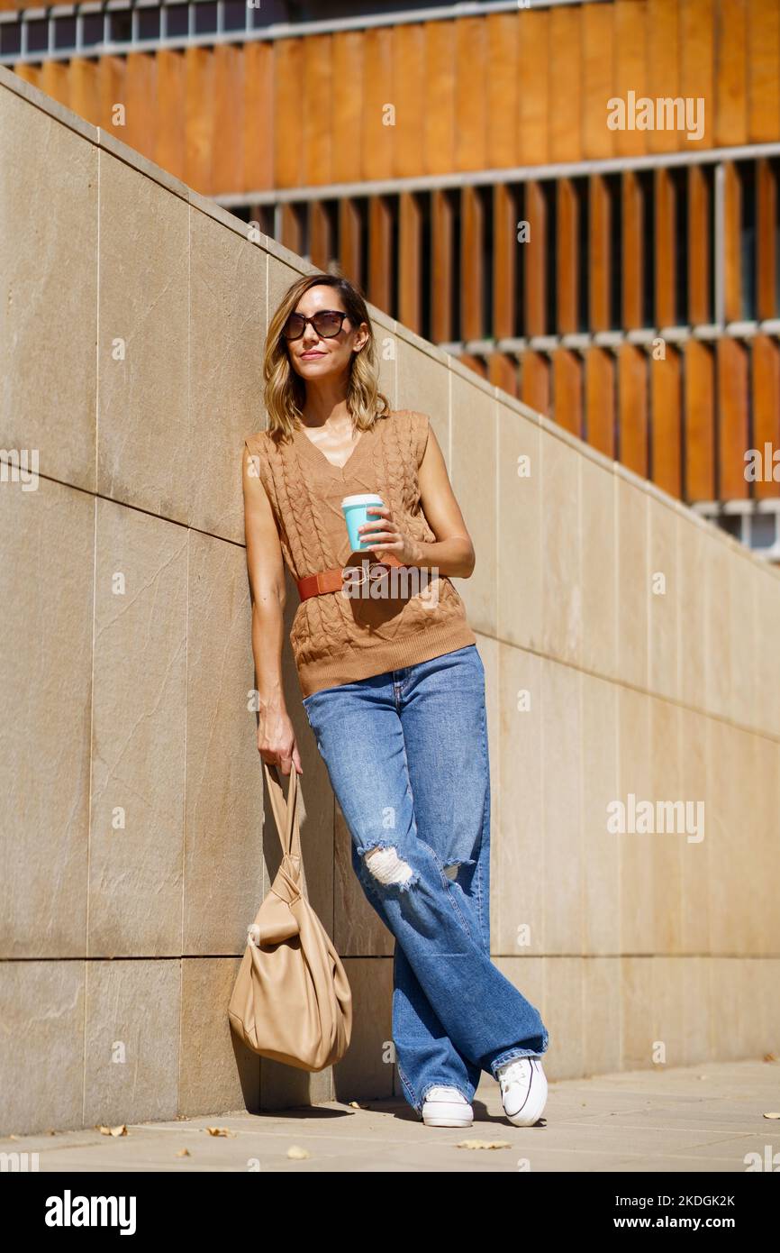 Elegante donna con caffè sulla strada Foto Stock