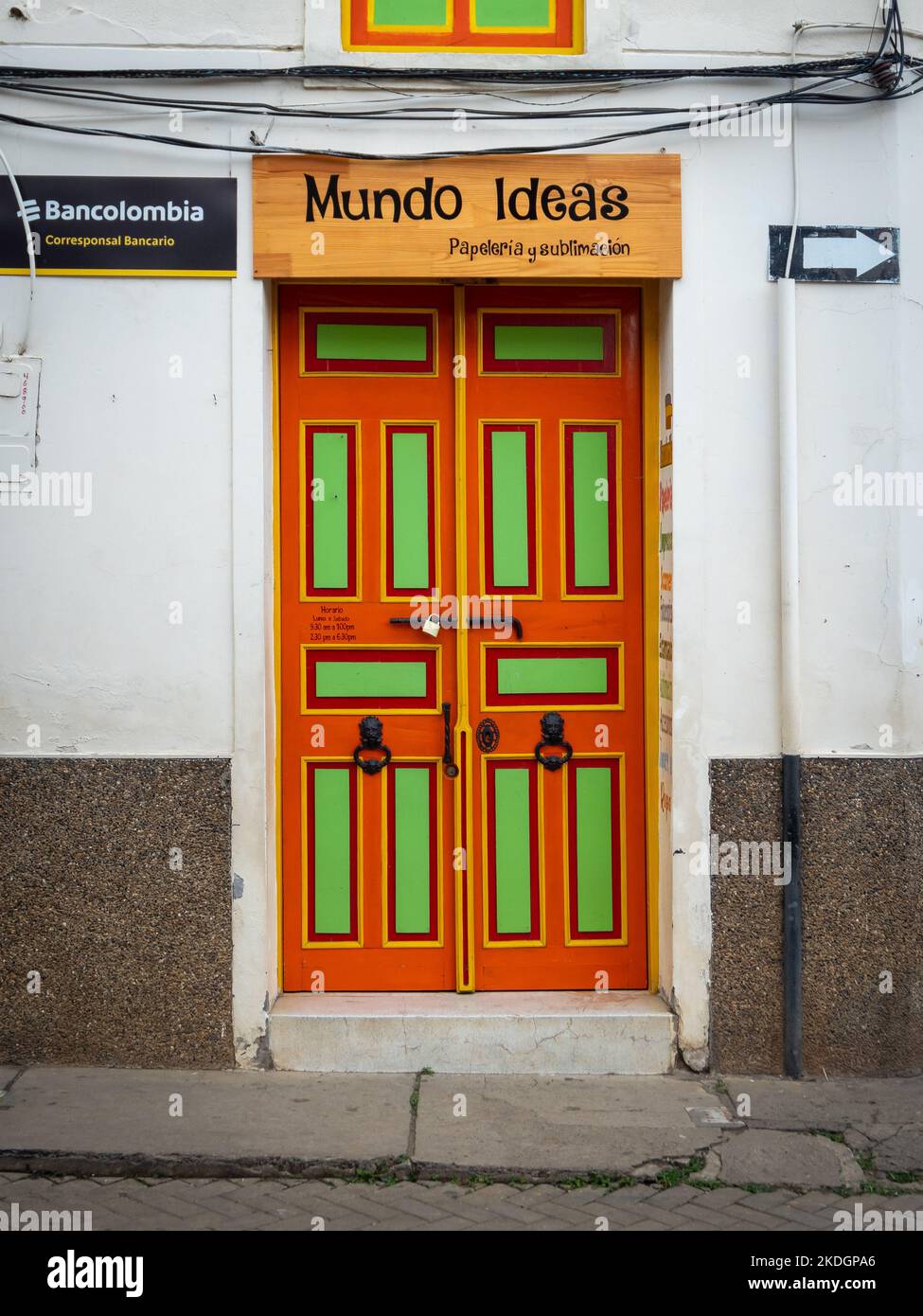 Jerico, Antioquia, Colombia - Aprile 3 2022: Porta verde e arancione su sfondo bianco, con un segno che recita 'Stationery and sublimation' Foto Stock