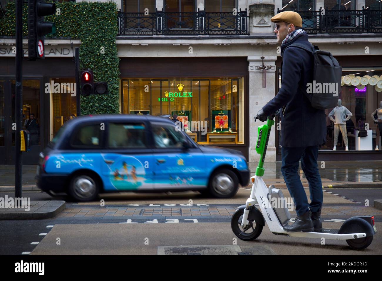 Smart Young Man Riding on Lime + Uber Scooter elettrico in Regent Street Westminster London West End Foto Stock