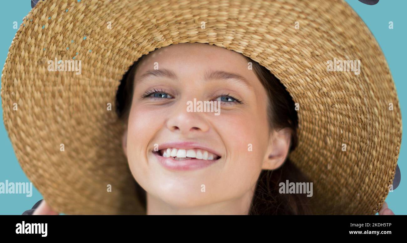 Primo piano ritratto di una giovane donna caucasica sorridente che indossa un cappello di paglia Foto Stock