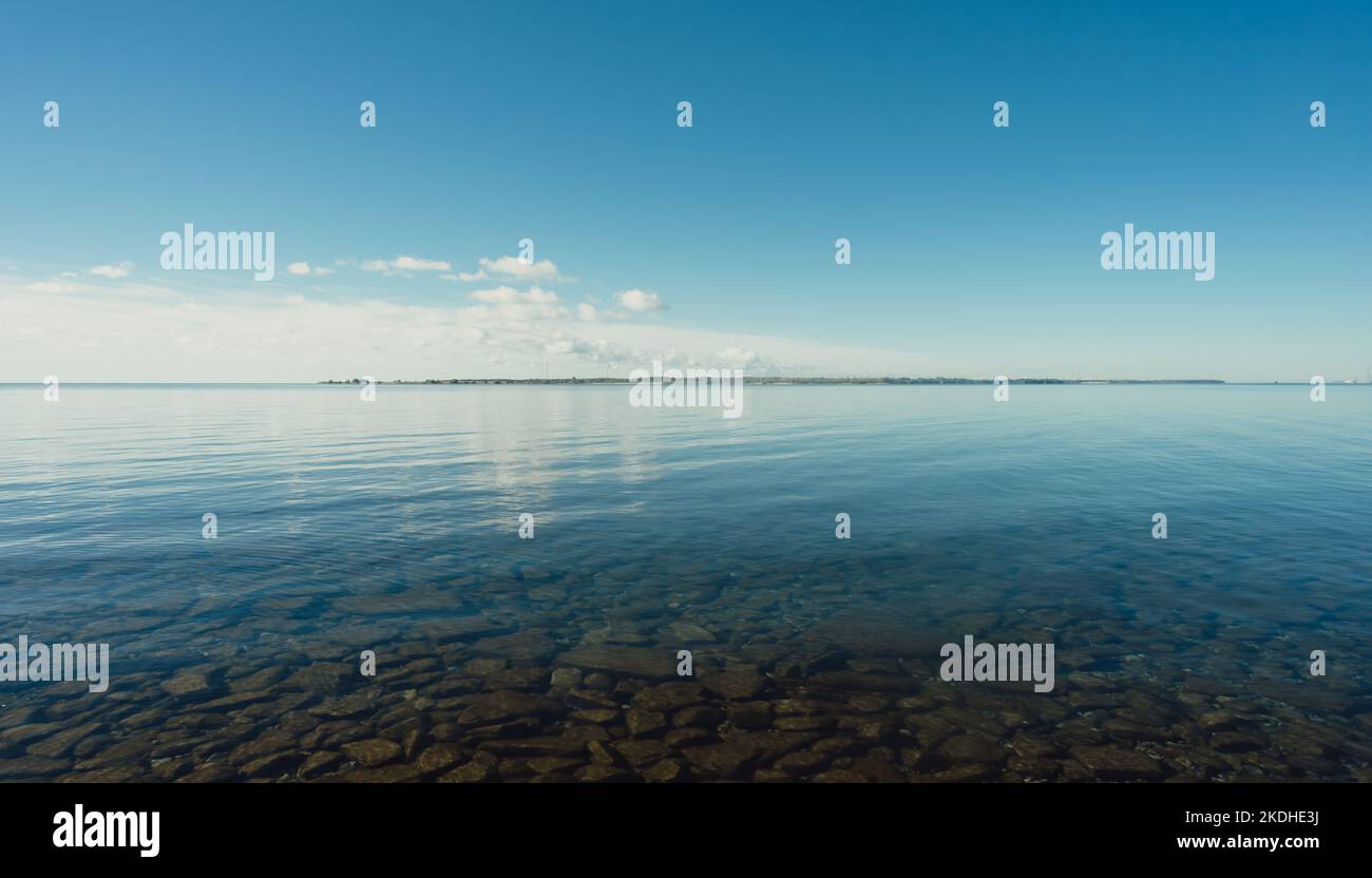 Acque calme del lago Ontario in una giornata di sole scattata dalla costa. Foto Stock