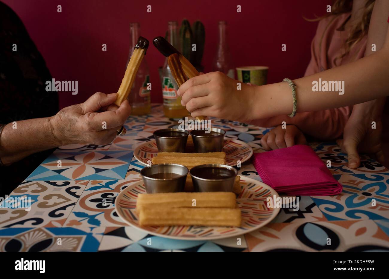 La famiglia mangia churros insieme in un ristorante messicano Foto Stock