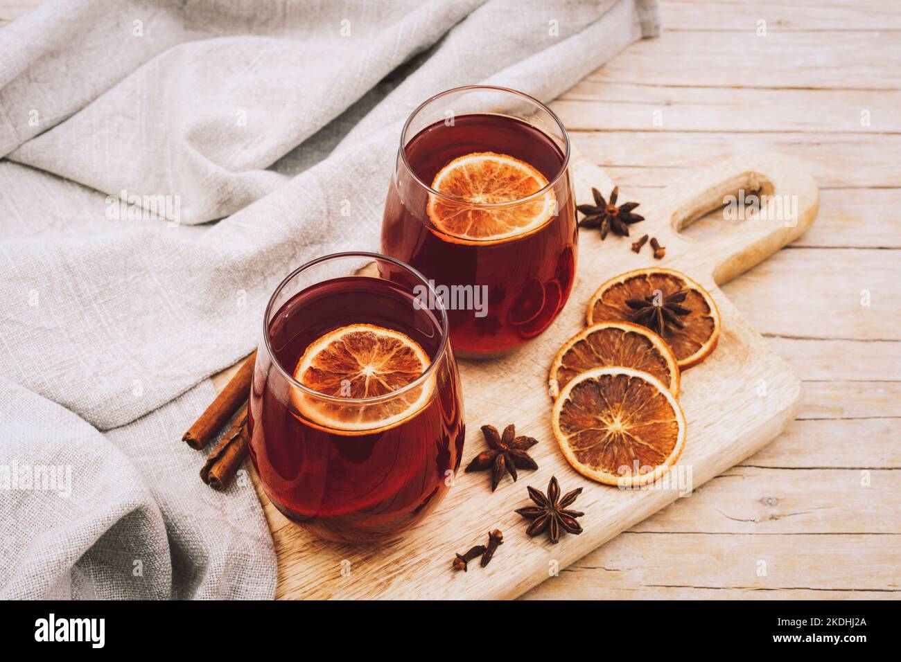 Due bicchieri con VIN brulé sul tagliere di legno con spezie e fette di arancia, vista dall'alto. Foto Stock