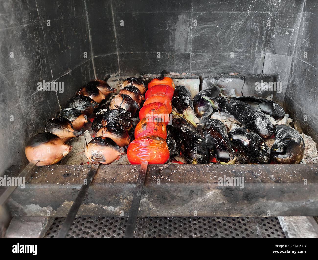 Le verdure sugli spiedini sono fritte sulle carboni. Cipolle, pomodori, melanzane alla griglia. Picnic Foto Stock