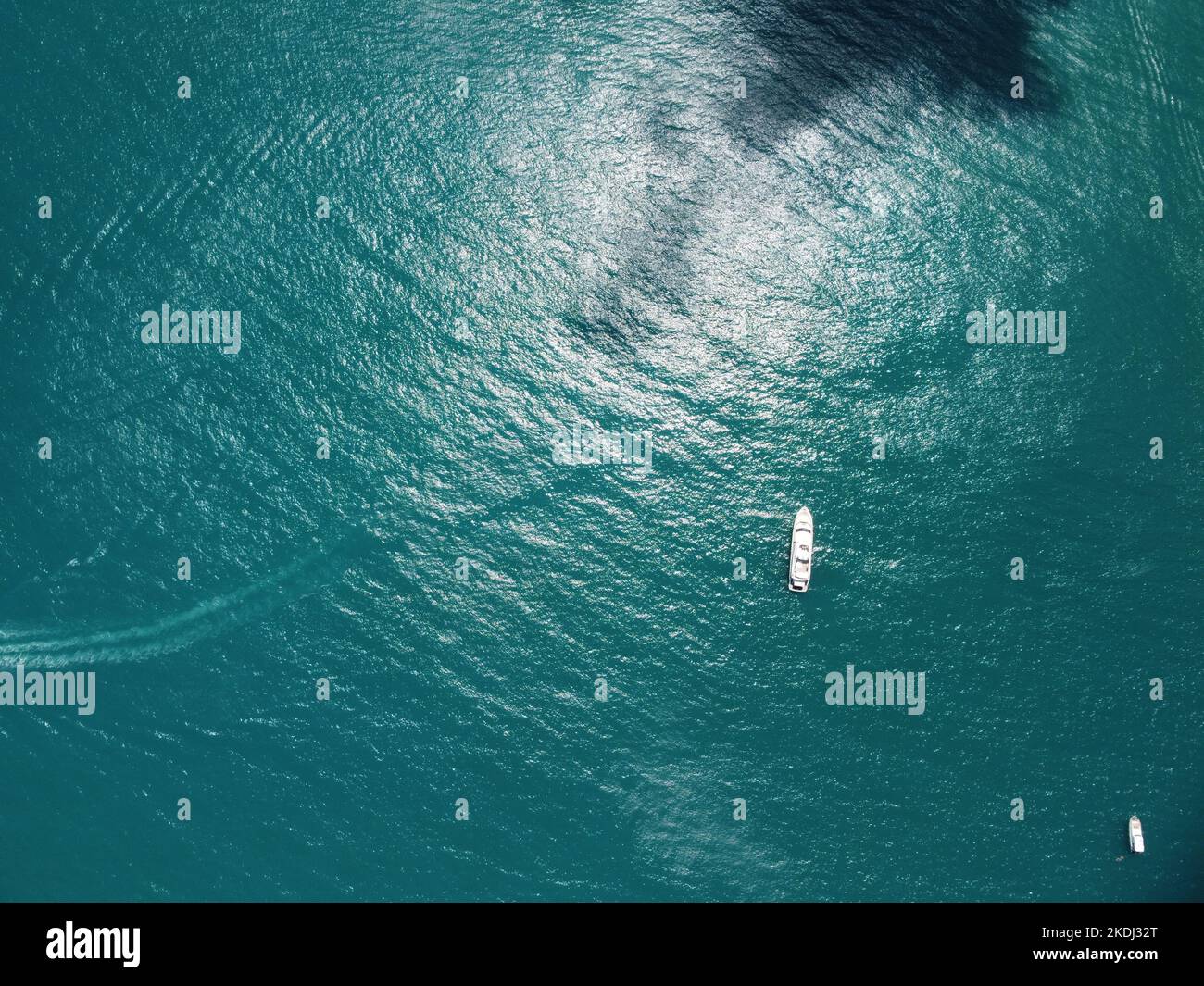 Yacht aereo sul mare calmo. Crociera di lusso. Vista dall'alto della barca bianca su acque blu profonde. Vista aerea di un ricco yacht a vela mare. Viaggio estivo Foto Stock