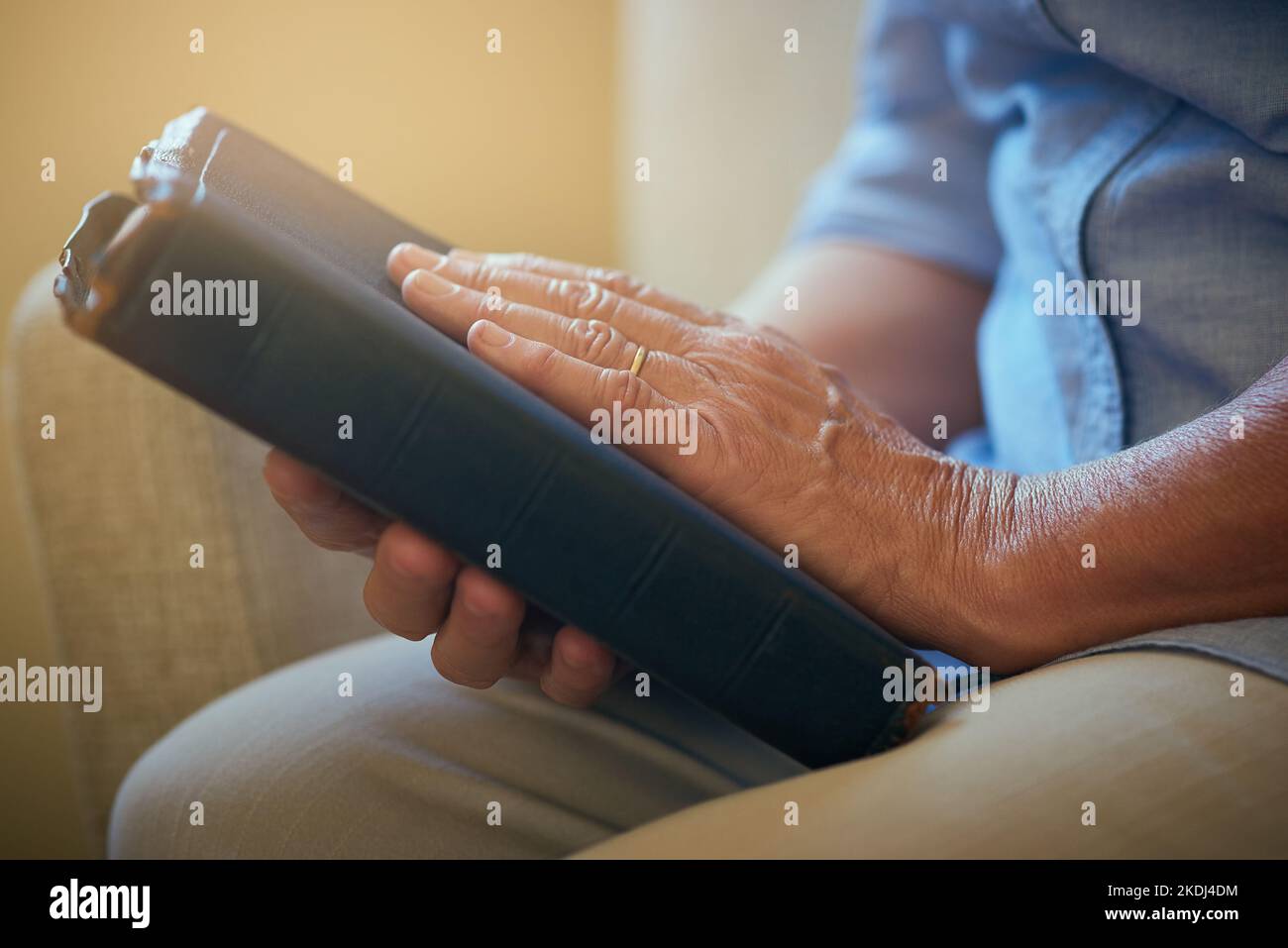La sua colonna di forza. Primo piano di una donna anziana in possesso di una Bibbia a casa. Foto Stock