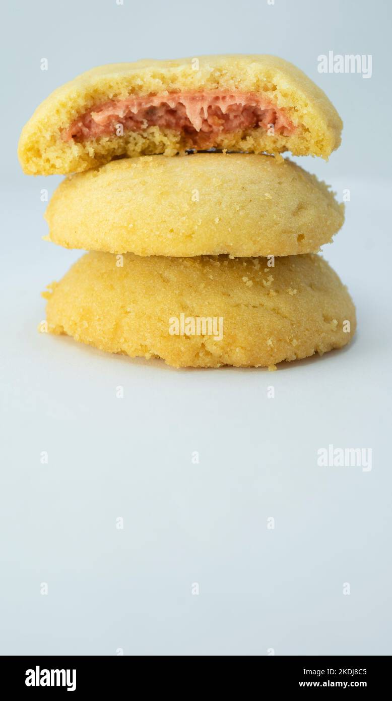 Pila di biscotti con crema di fragole closeup isolato su sfondo blu Foto Stock