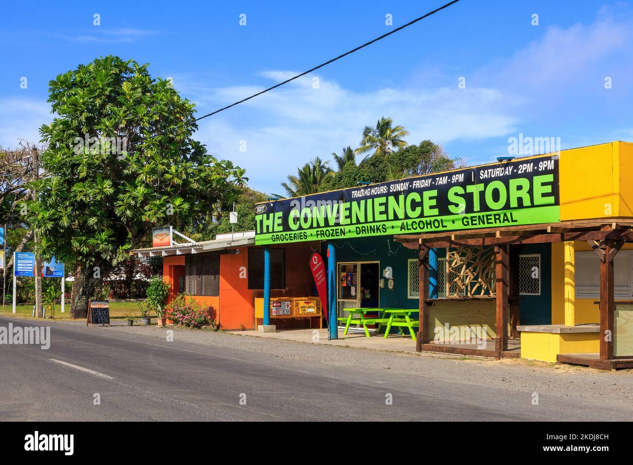 Un minimarket nella città di muri Beach, Rarotonga, Cook Islands, con un albero di pane che cresce accanto ad esso Foto Stock