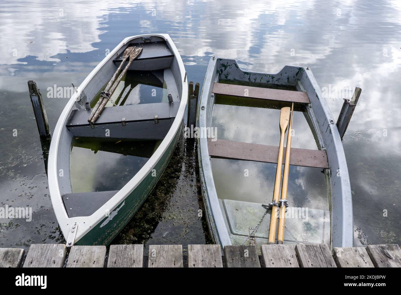 due piccole barche a remi naufragate piene d'acqua su un lago Foto Stock