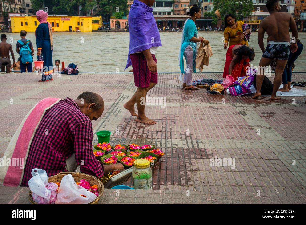 Luglio 8th 2022 Haridwar India. Un uomo che vende fiori colorati sulle rive o ghats del fiume Gange per i rituali indù. Foto Stock