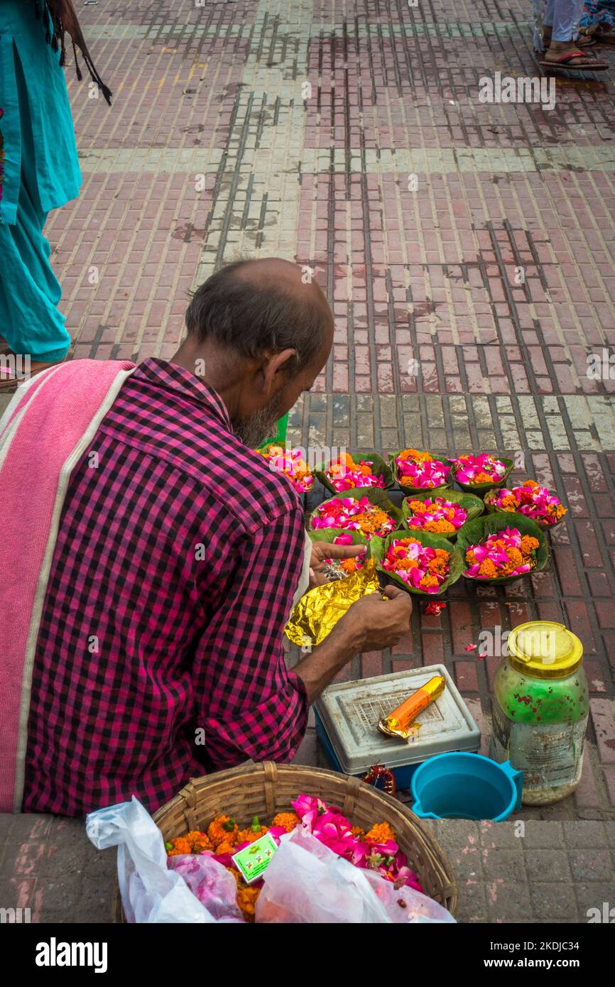 Luglio 8th 2022 Haridwar India. Un uomo che vende fiori colorati sulle rive o ghats del fiume Gange per i rituali indù. Foto Stock