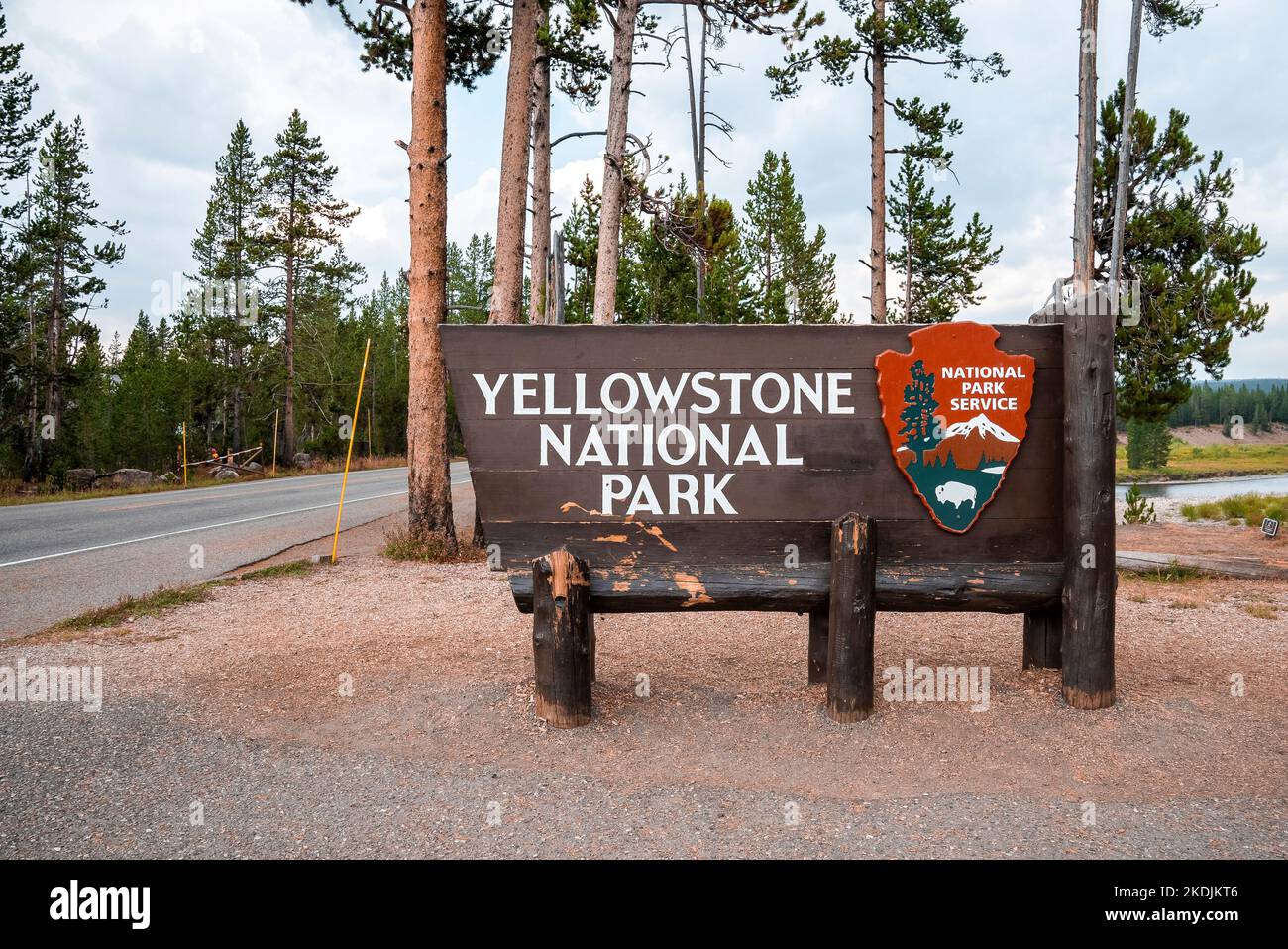 Cartello all'entrata contro gli alberi del famoso Parco Nazionale di Yellowstone Foto Stock