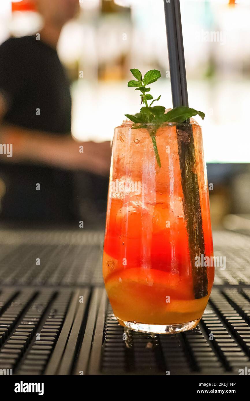 Un classico bicchiere da cocktail con barman fuori fuoco sullo sfondo Foto Stock