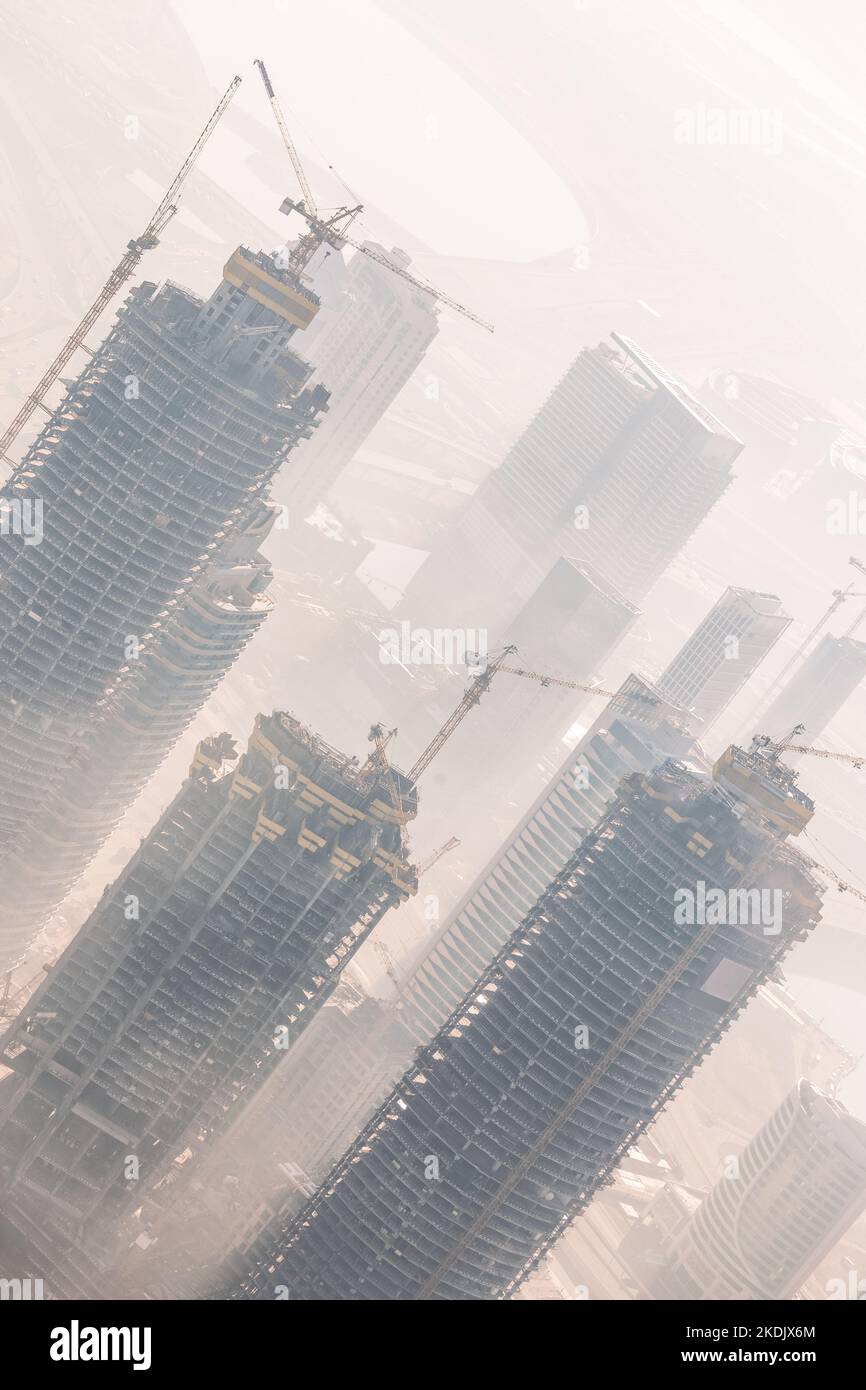 Enorme skyscrappers sito in costruzione di gru sulla sommità di edifici. Rapid urban e di costruzione per lo sviluppo del settore o l'inflazione immobiliare bolla. Foto Stock