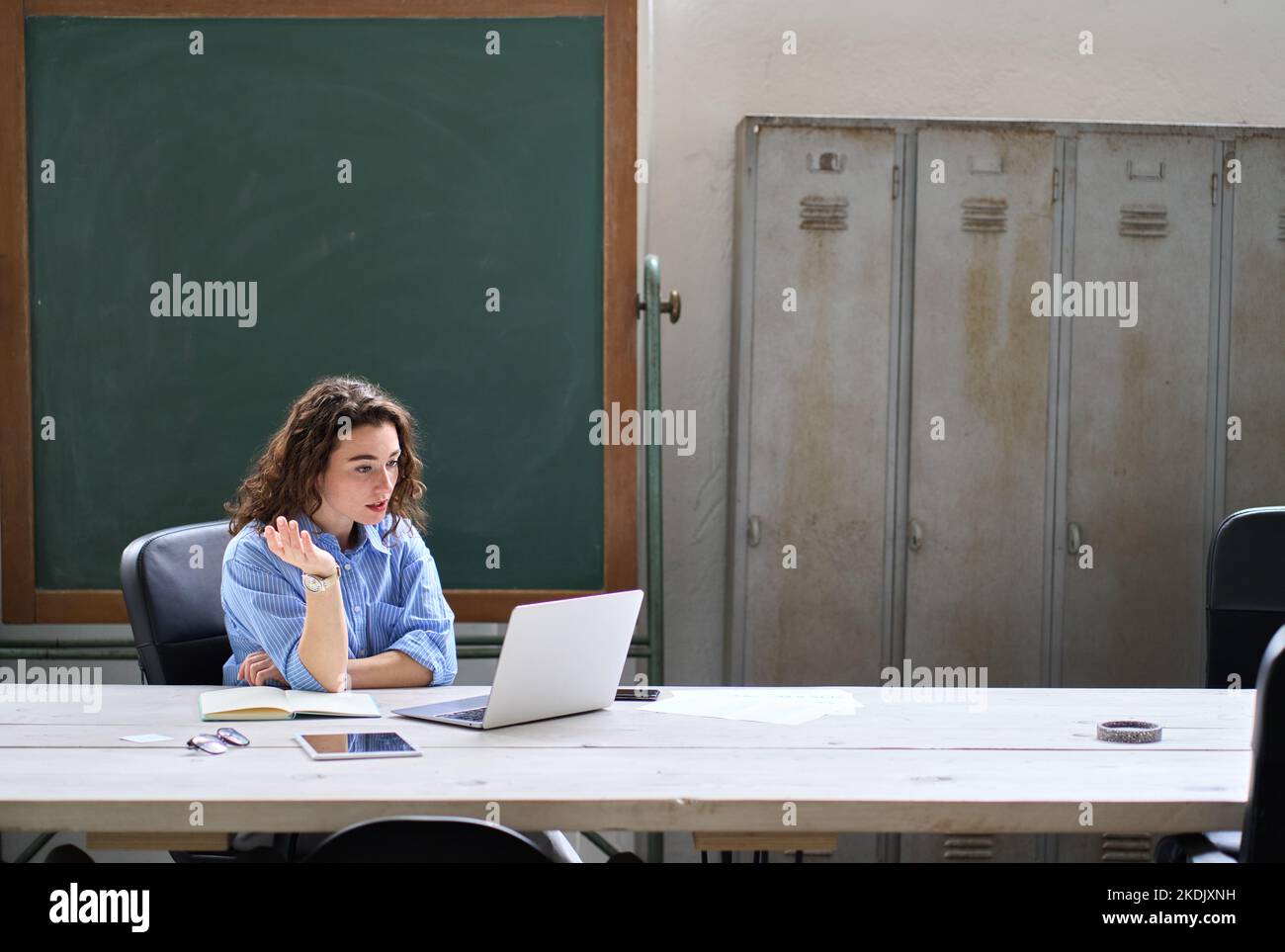 Giovane donna insegnante online che insegna in classe a distanza sul computer portatile in classe. Foto Stock