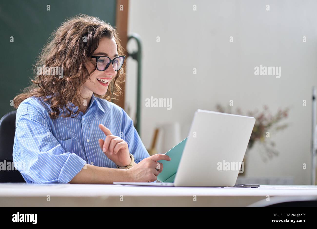 Giovane donna d'affari leader ibrido video chiamata in remoto in ufficio. Foto Stock
