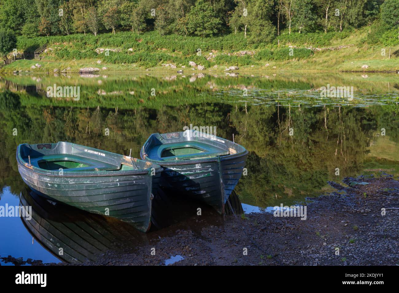 Barche a remi ormeggiate a Watendlath Tarn nel Lake District Cumbria Foto Stock
