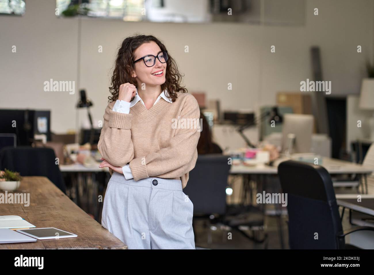 Giovane donna positiva felice di affari professionale in piedi in ufficio. Foto Stock