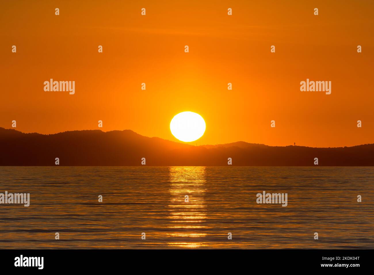 Vista panoramica del globo del sole che si riflette sul mare Mediterraneo al tramonto dorato nel sud della Francia Foto Stock