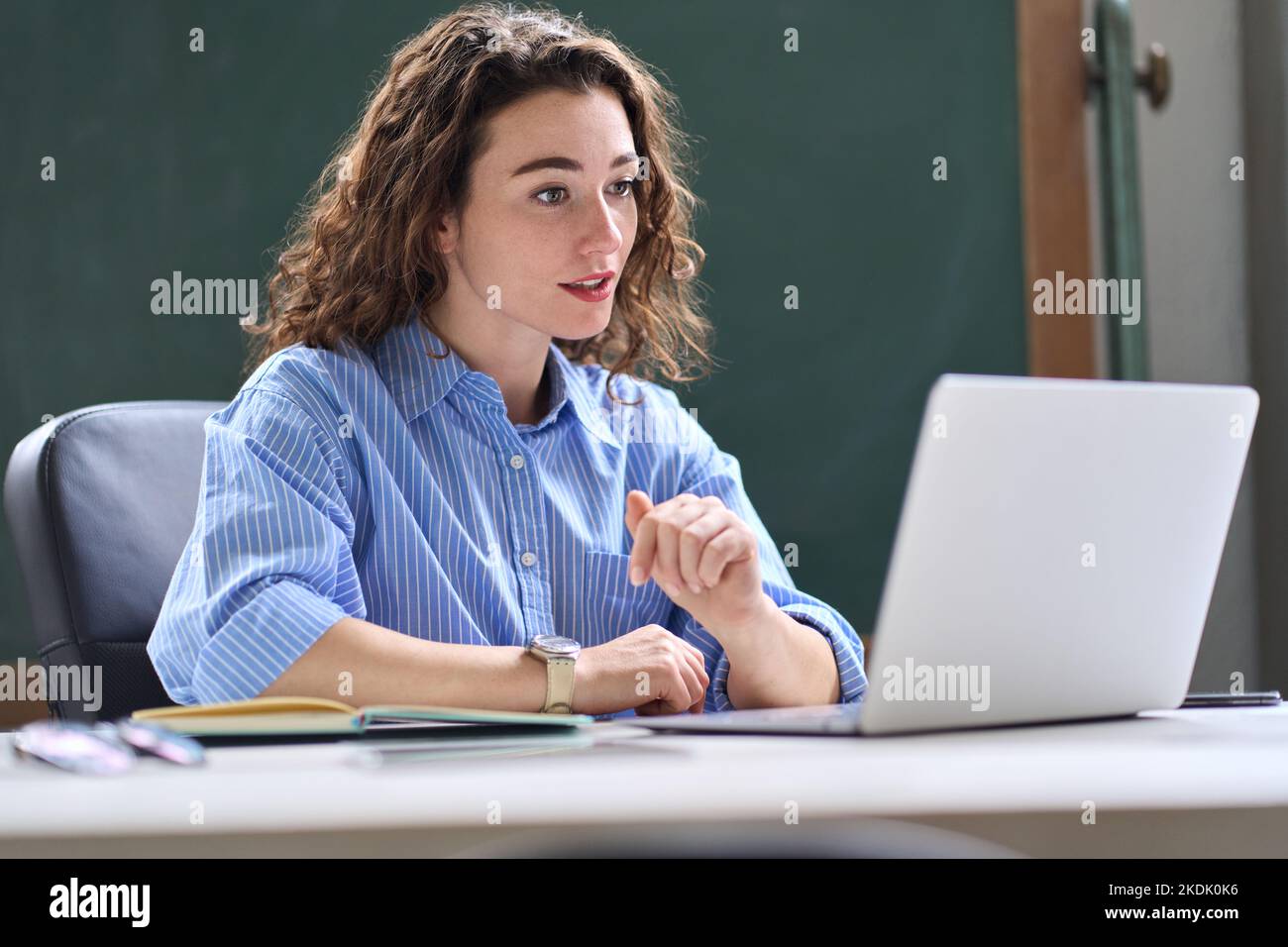 Giovane donna, insegnante femminile che insegna classe remota on-line che lavora in ufficio. Foto Stock