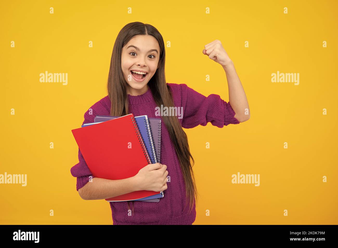 Faccia eccitata. Adolescente scuola ragazza con libri isolato studio sfondo. Espressione stupita, allegra e felice. Foto Stock