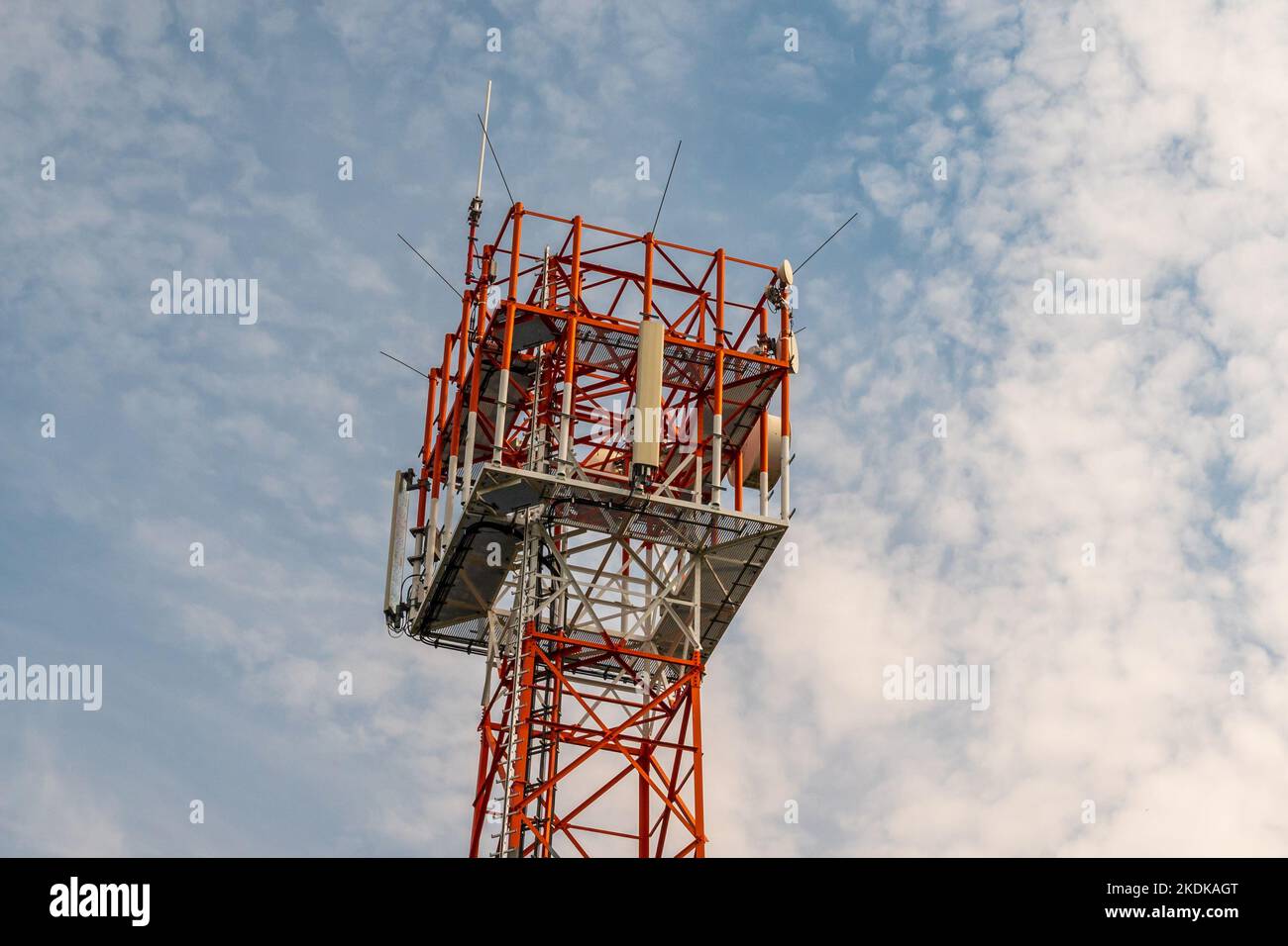 Primo piano di una torre di telecomunicazioni contro le nuvole e il cielo blu Foto Stock