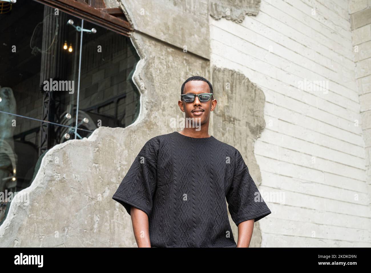 Ritratto di bel giovane uomo nero che indossa occhiali da sole all'aperto Foto Stock
