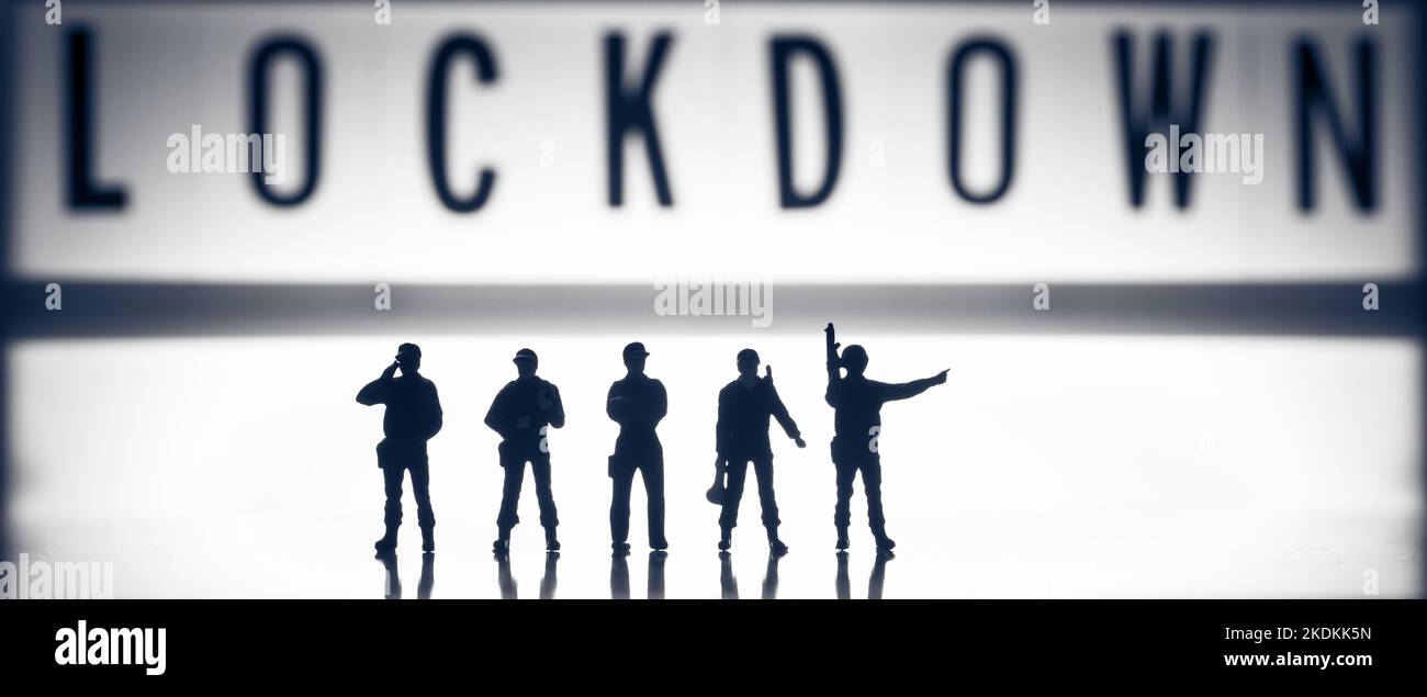 EDITORIALE ILLUSTRATIVO - Lockdown Concept images - basso tasto bianco e nero (b & w) personaggi giocattolo in miniatura delle forze di sicurezza - silhouette di esercito o pol Foto Stock
