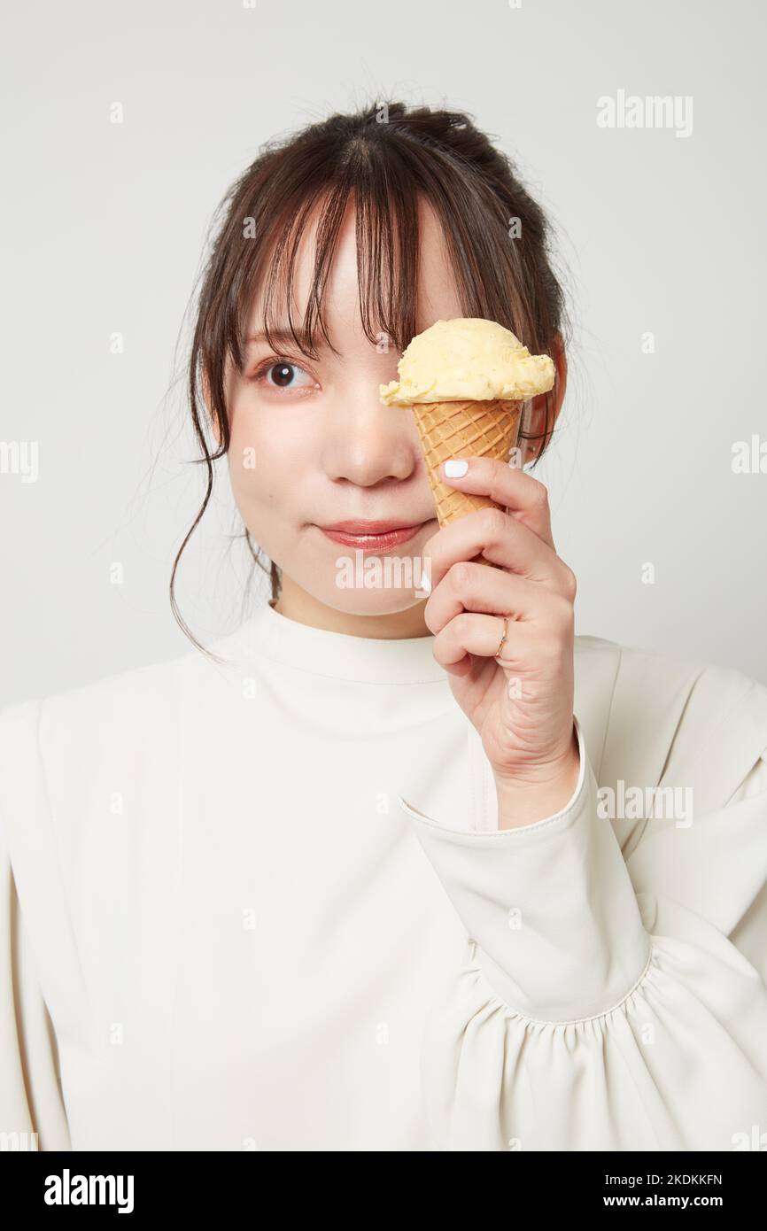 Giovane donna giapponese che mangia gelato Foto Stock