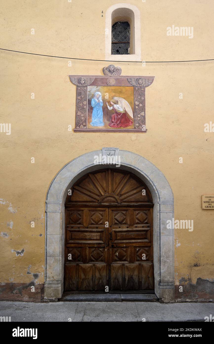 Affresco e ingresso alla Cappella o Chapelle Notre Dame des Grâces nel quartiere storico o nel centro storico di Colmars-les-Alpes Alpes Alpes-de-Haute-Provence Francia Foto Stock