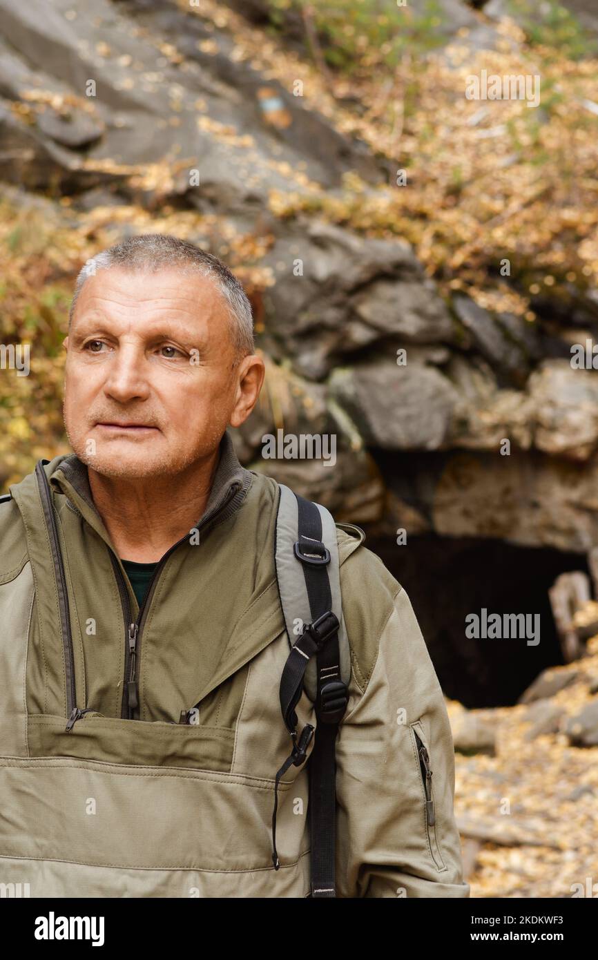 Ritratto di un uomo anziano. Un viaggio alle vecchie miniere di mica nei Monti Urali. Un turista anziano esplora le vecchie grotte abbandonate Foto Stock