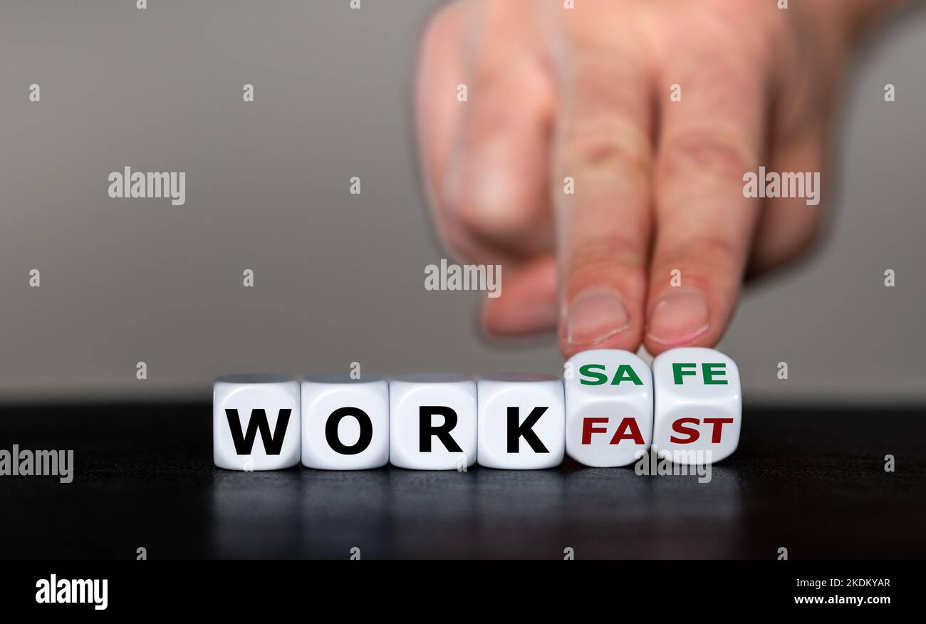 La mano gira i dadi e cambia l'espressione "lavoro veloce" in "lavoro sicuro". Foto Stock