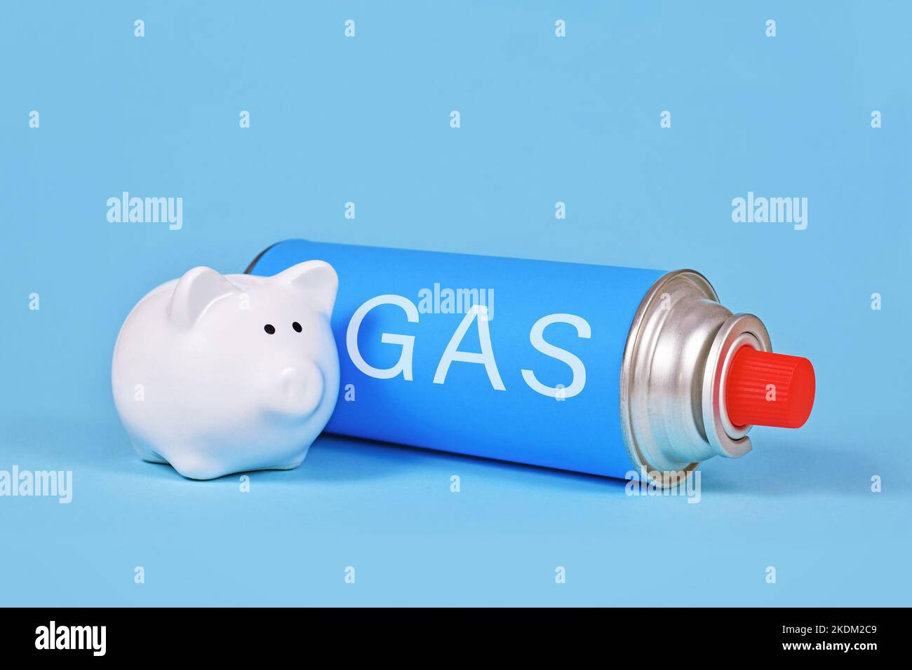 Flacone a cartuccia di gas con banco di piggy su sfondo blu. Concetto per il risparmio di gas. Foto Stock