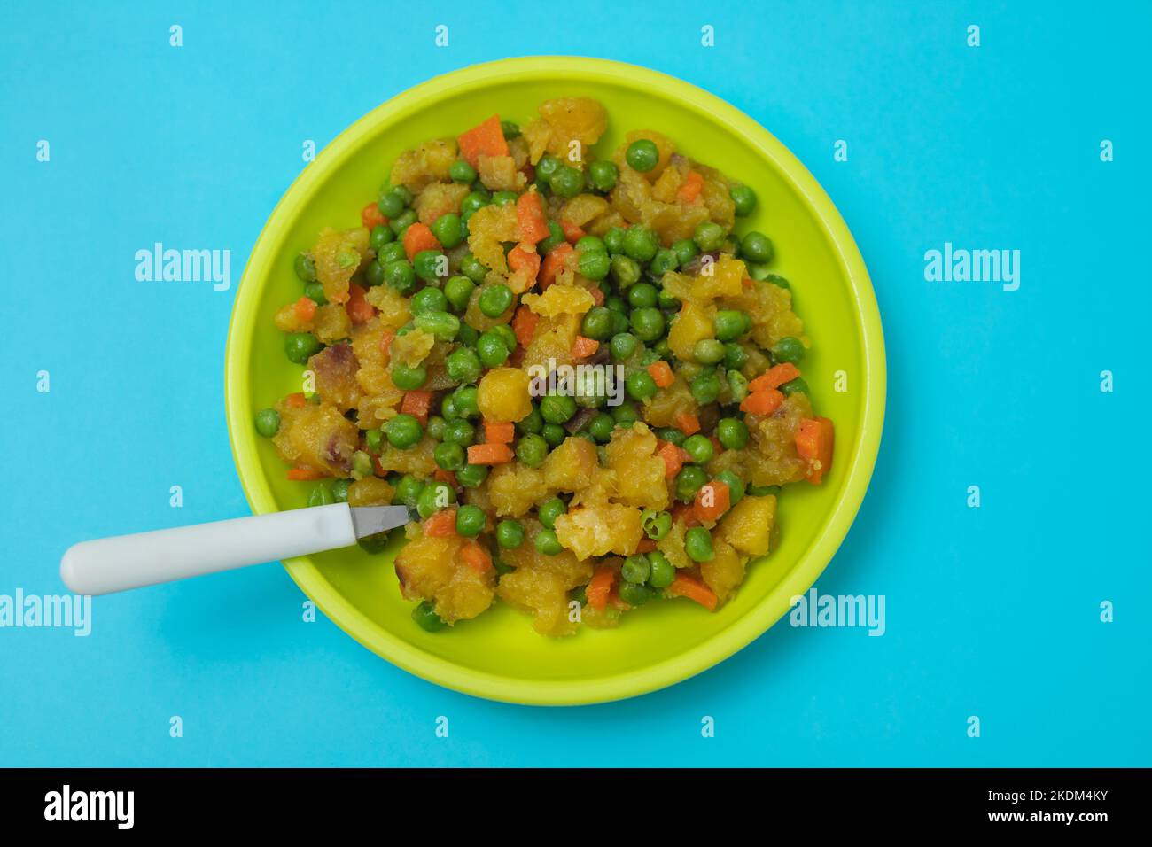 verdure miste piselli, carote, piatto di patate per bambini su blu Foto Stock