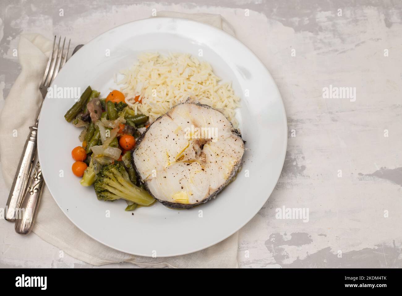 verdure al forno con pesce bollito su piatto bianco in ceramica Foto Stock