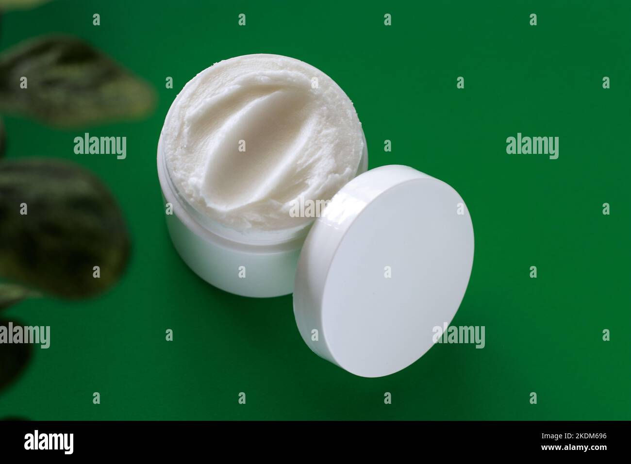 mock up di vaso bianco di crema su uno sfondo verde, con spazio copia Foto Stock